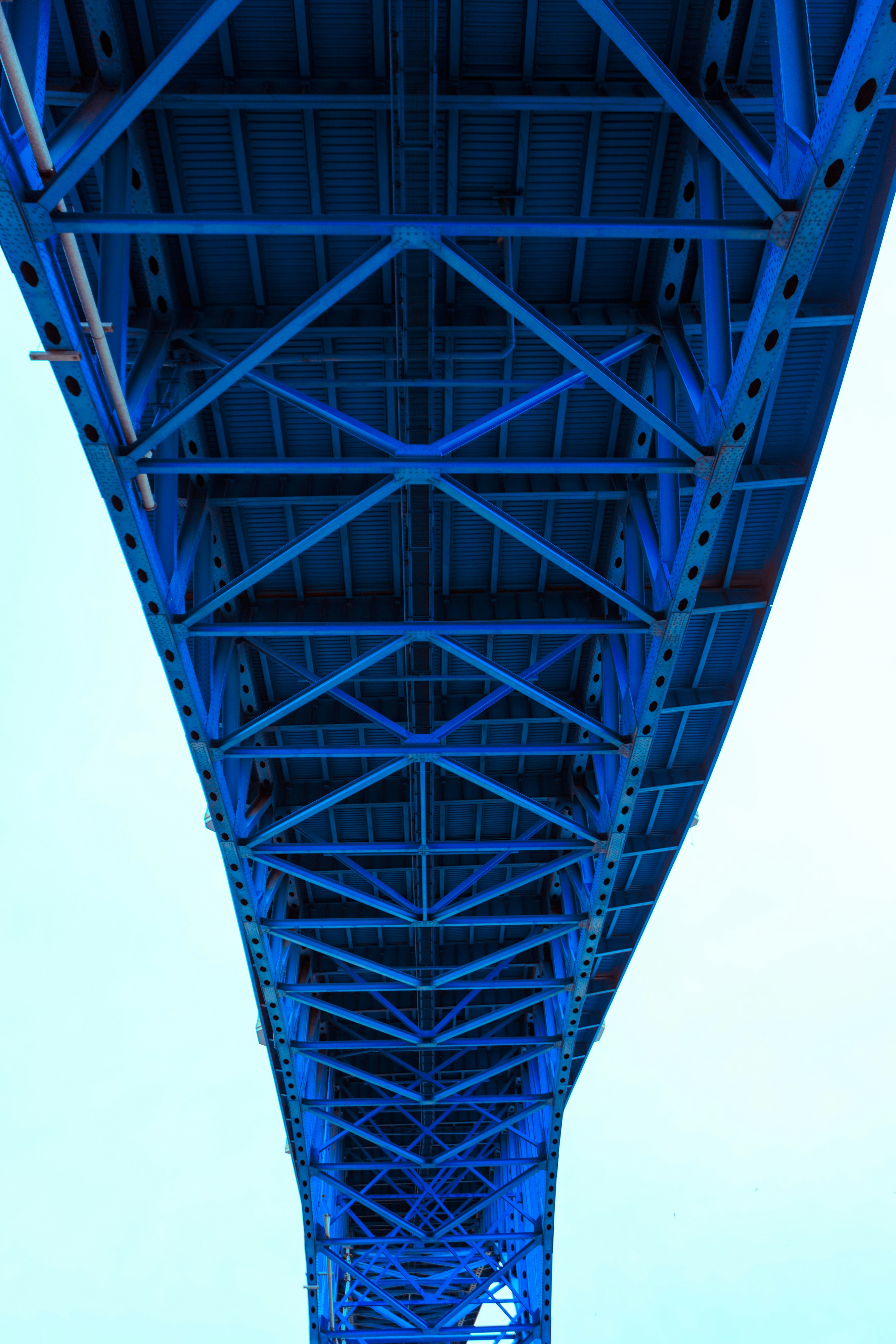 the underside of a bridge with a blue metal structure