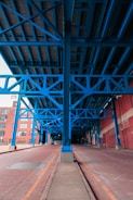 a blue metal structure with a red brick building in the background