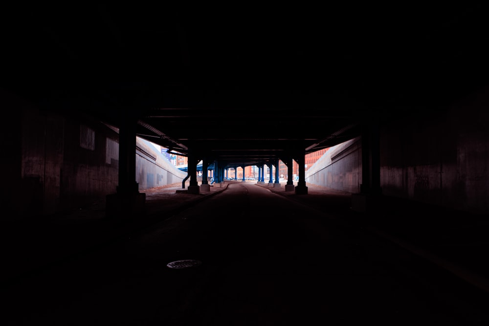 a dark tunnel with a few people walking in it