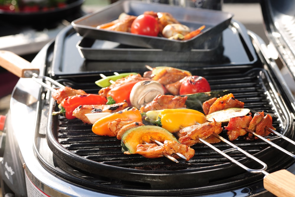 a close up of a grill with meat and vegetables on it