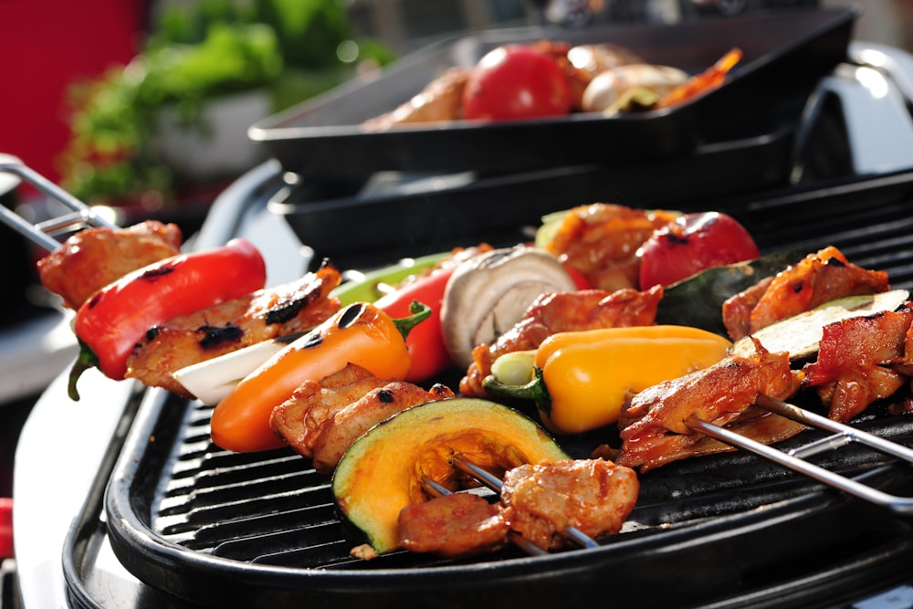 a close up of a grill with meat and vegetables on it