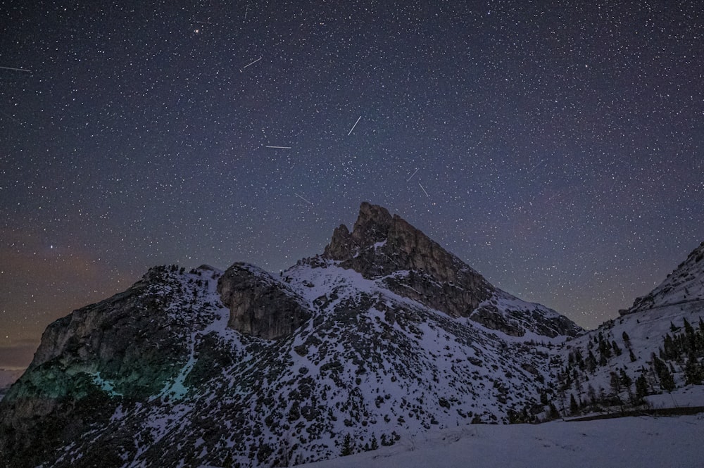 the night sky over a snowy mountain range