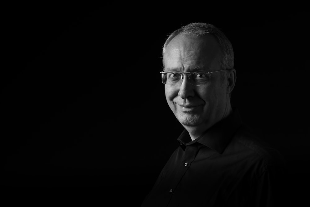 a black and white photo of a man wearing glasses