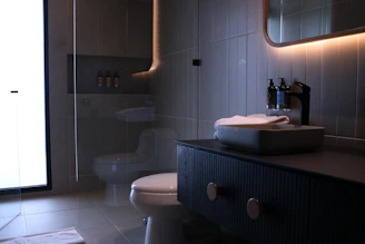 a bathroom with a toilet, sink and mirror