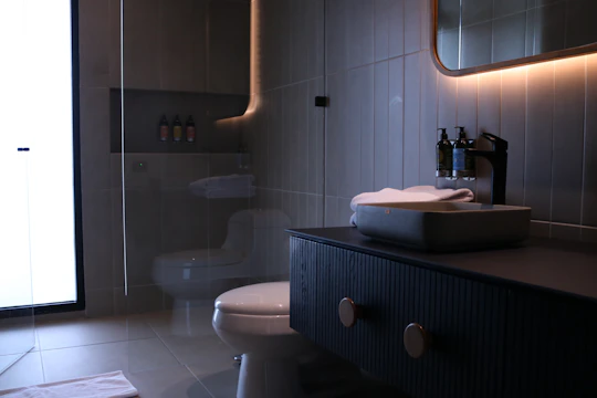 a bathroom with a toilet, sink and mirror