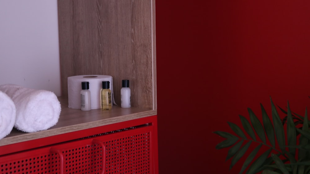 a bathroom with a red cabinet and white towels