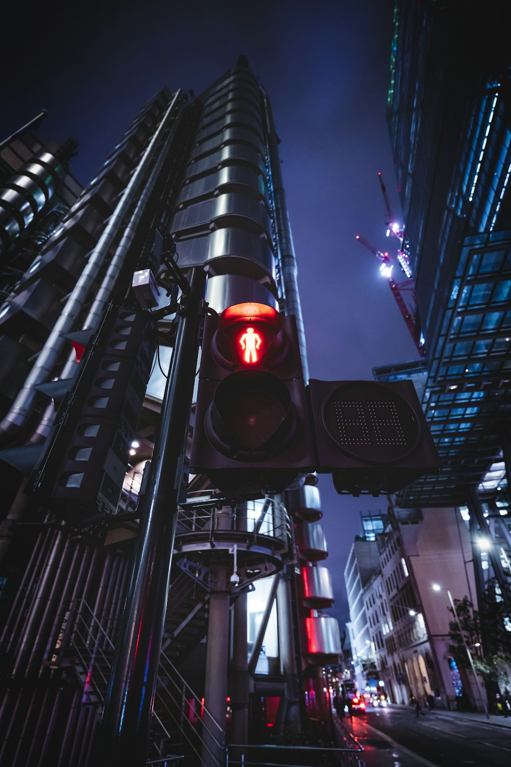 Eine Ampel an einem Mast in einer Stadt bei Nacht