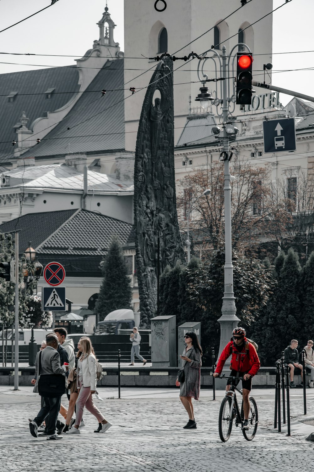 a group of people walking down a street next to a traffic light