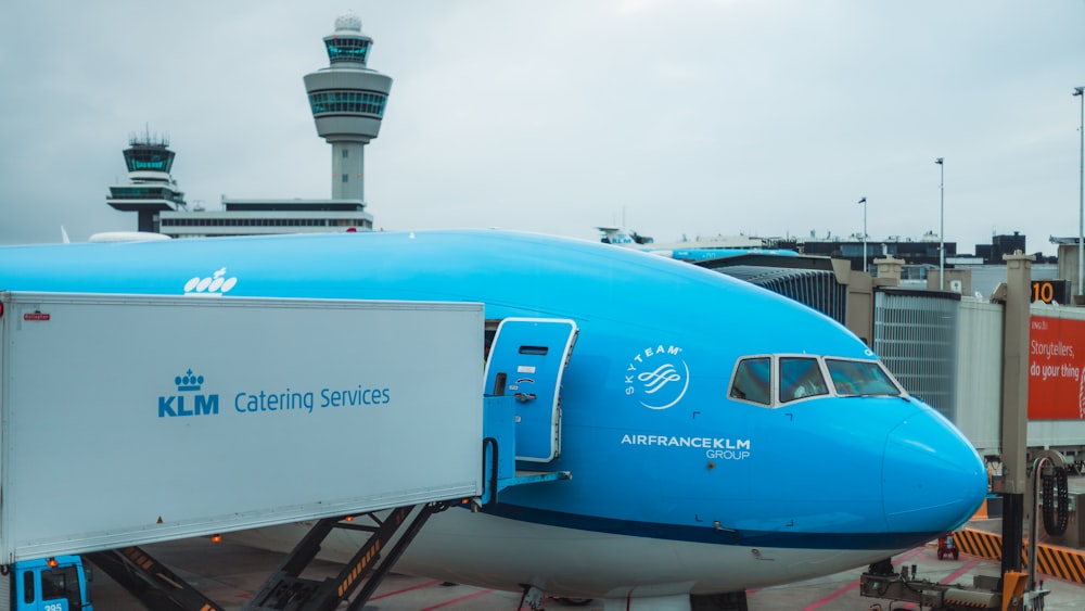 a blue and white airplane is parked at an airport