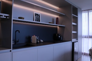 Modern kitchen drawers featuring minimalist black handles in a bright setting.