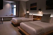 Bright and clean standard room with twin beds and tasteful artwork on the walls.
