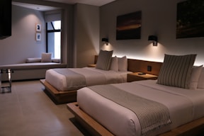 Spacious room featuring comfortable beds and neat furnishings.