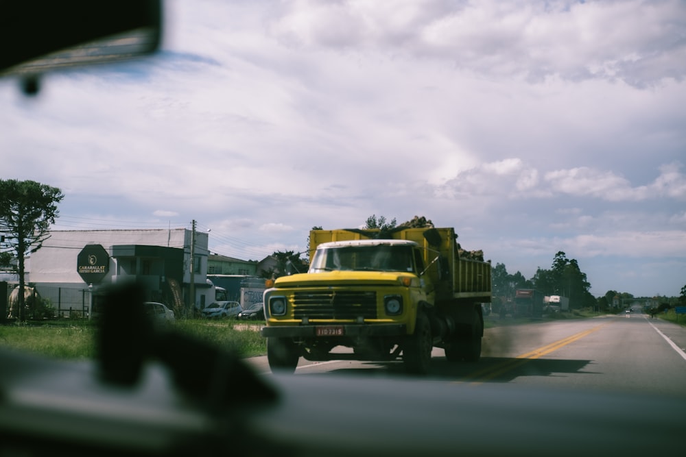 a large yellow truck driving down a street