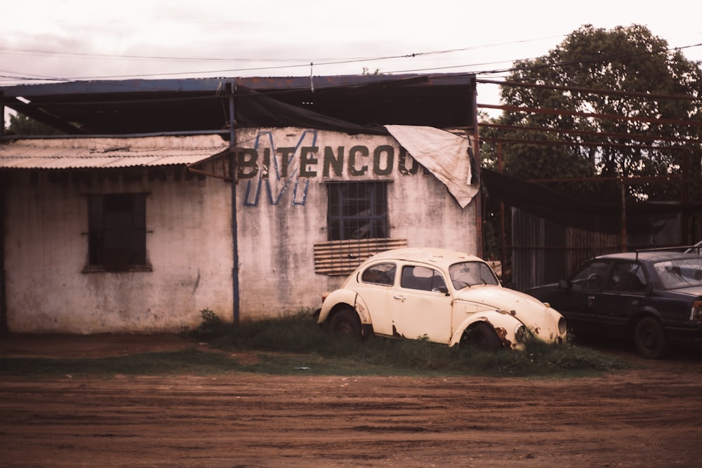 an old white car parked in front of a building