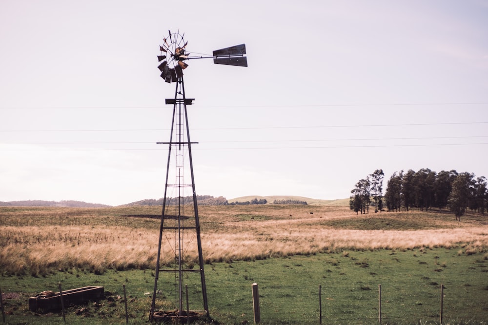 a windmill in a field with a sky background