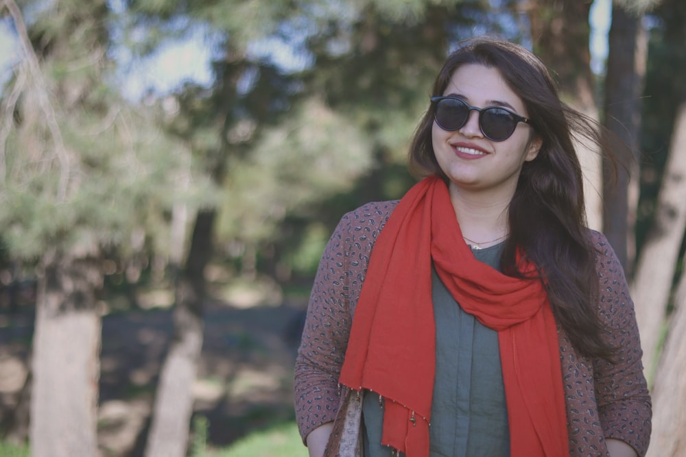 a woman wearing sunglasses and a red scarf