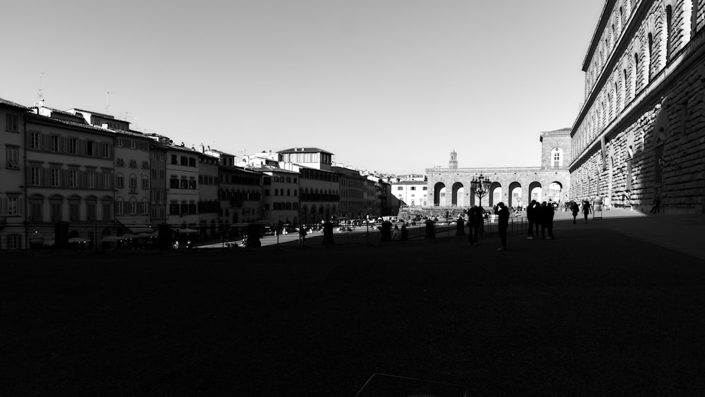 a black and white photo of people walking down a street