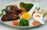 Grilled chicken breast served with steamed broccoli and sweet potatoes.