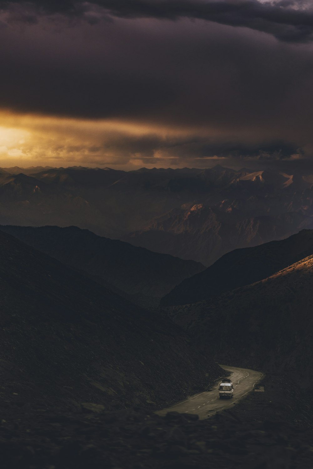 a car driving down a road in the mountains