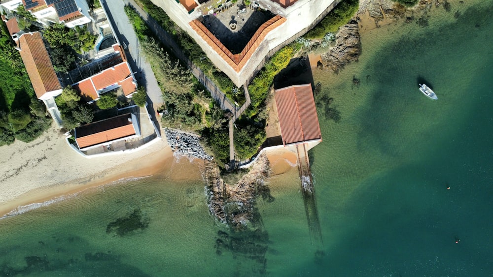 an aerial view of a beach with a boat in the water