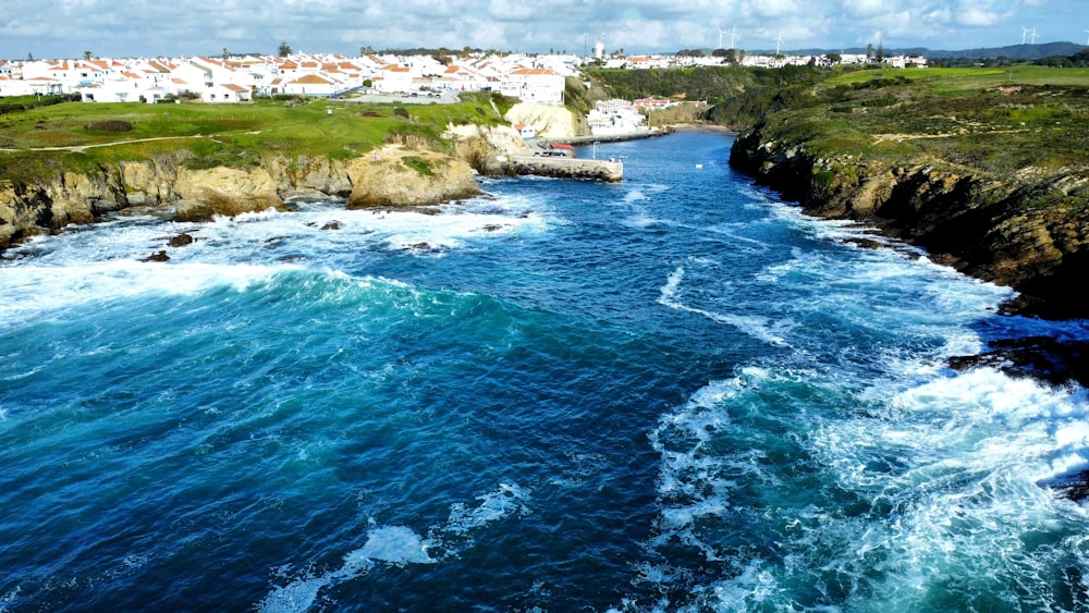 an aerial view of a body of water with a town in the background