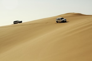 a couple of cars that are in the sand