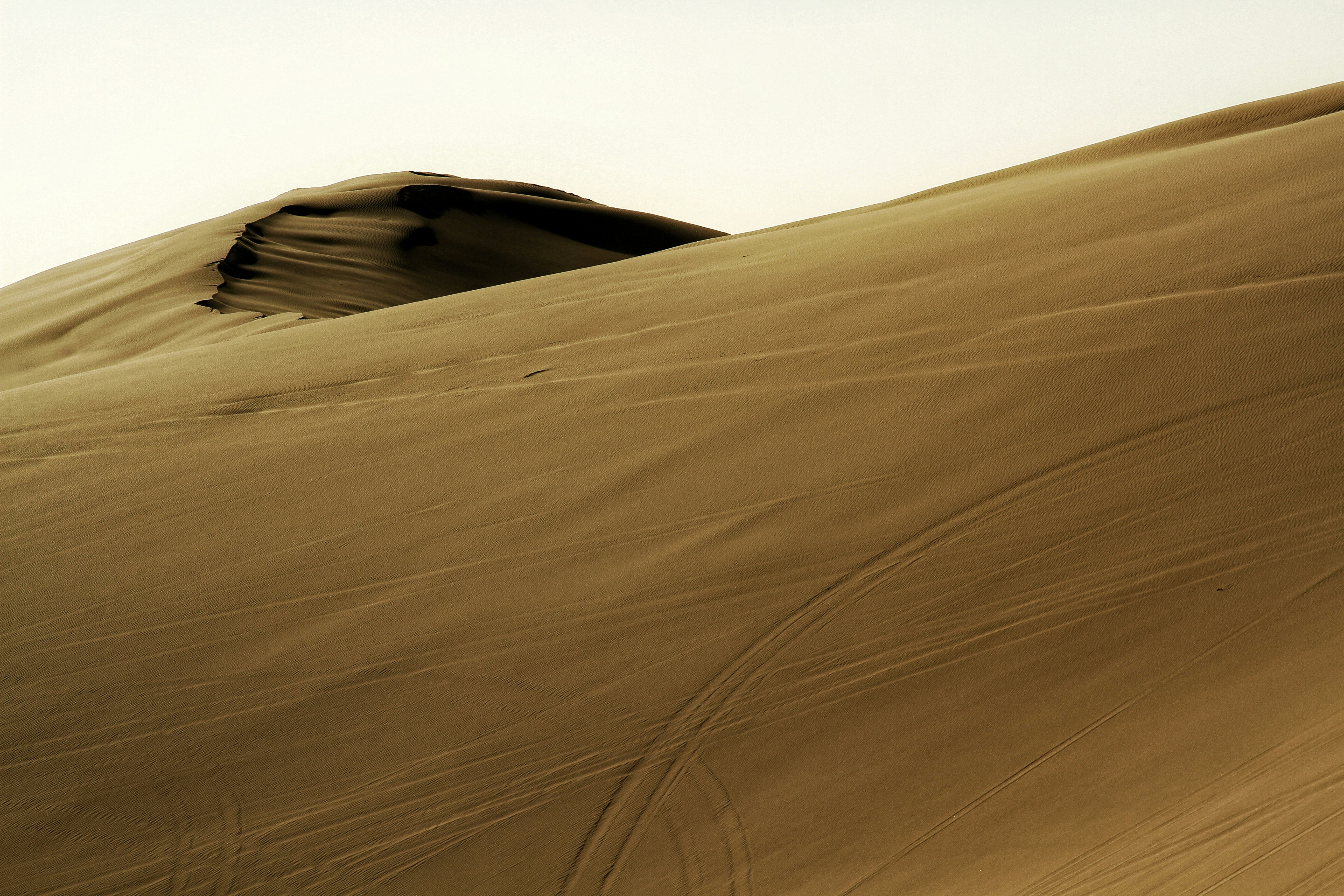 a man riding a snowboard down the side of a snow covered slope