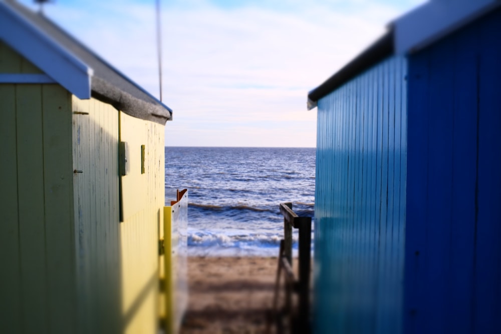 a couple of beach huts sitting on top of a sandy beach