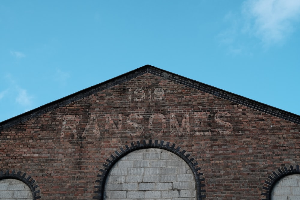 a brick building with two arched windows and graffiti on the side