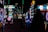 Dimly lit arcade scene with various brightly colored neon lights from different game machines. Several arcade machines, including Monopoly-themed and a large Connect Four game, line the room. The floor has a colorful carpet pattern, and overhead lights create a lively atmosphere.