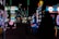 Dimly lit arcade scene with various brightly colored neon lights from different game machines. Several arcade machines, including Monopoly-themed and a large Connect Four game, line the room. The floor has a colorful carpet pattern, and overhead lights create a lively atmosphere.