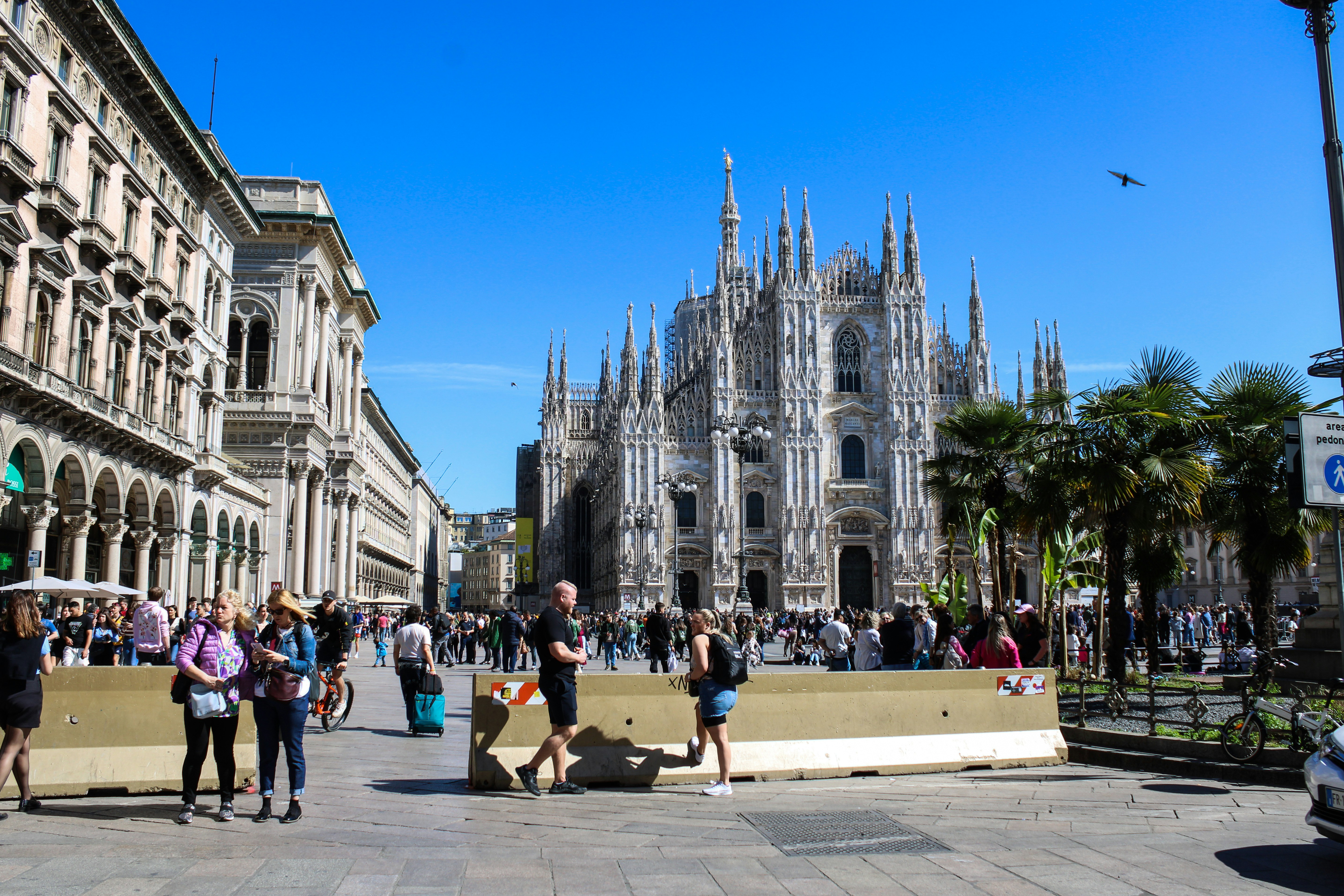 Un gruppo di persone che camminano lungo una strada accanto a edifici alti