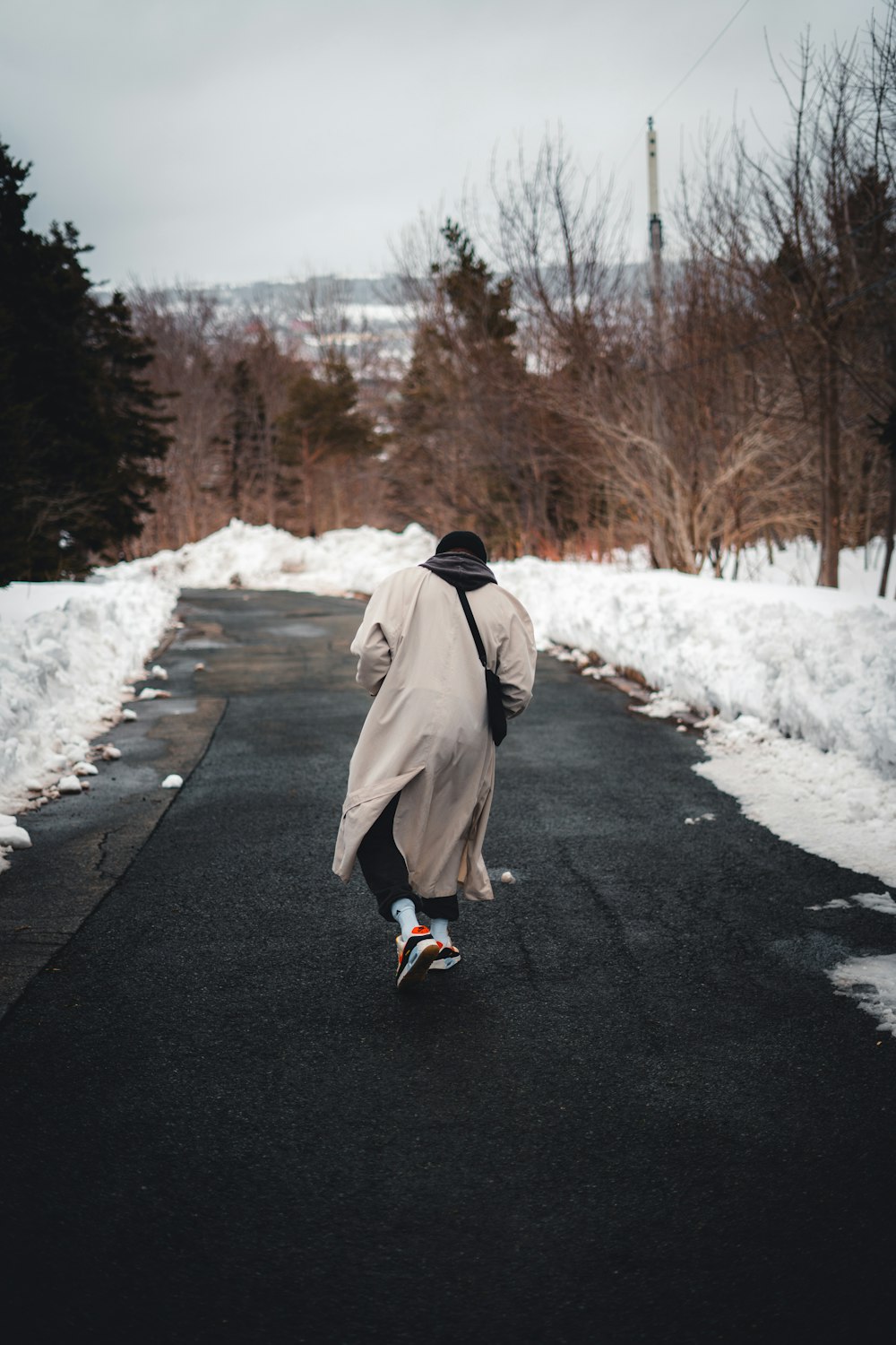 a person walking down a road in the snow