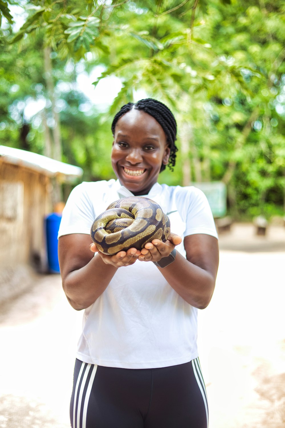 uma mulher segurando uma cobra grande em suas mãos