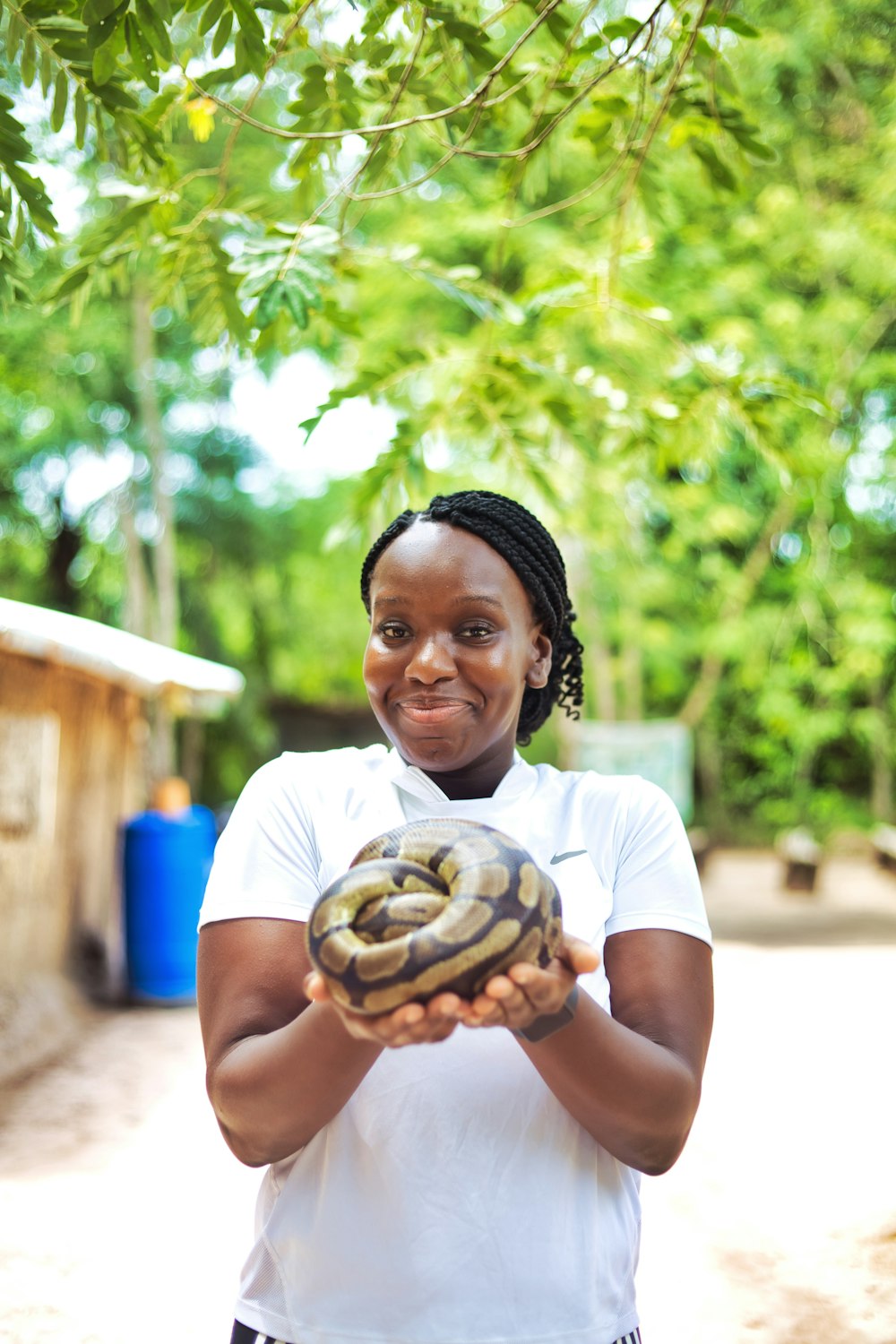 Una mujer sosteniendo una gran serpiente en sus manos