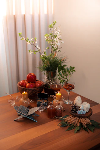 A stylish arrangement of home decor items including candles, vases, and cozy throws on a wooden table.