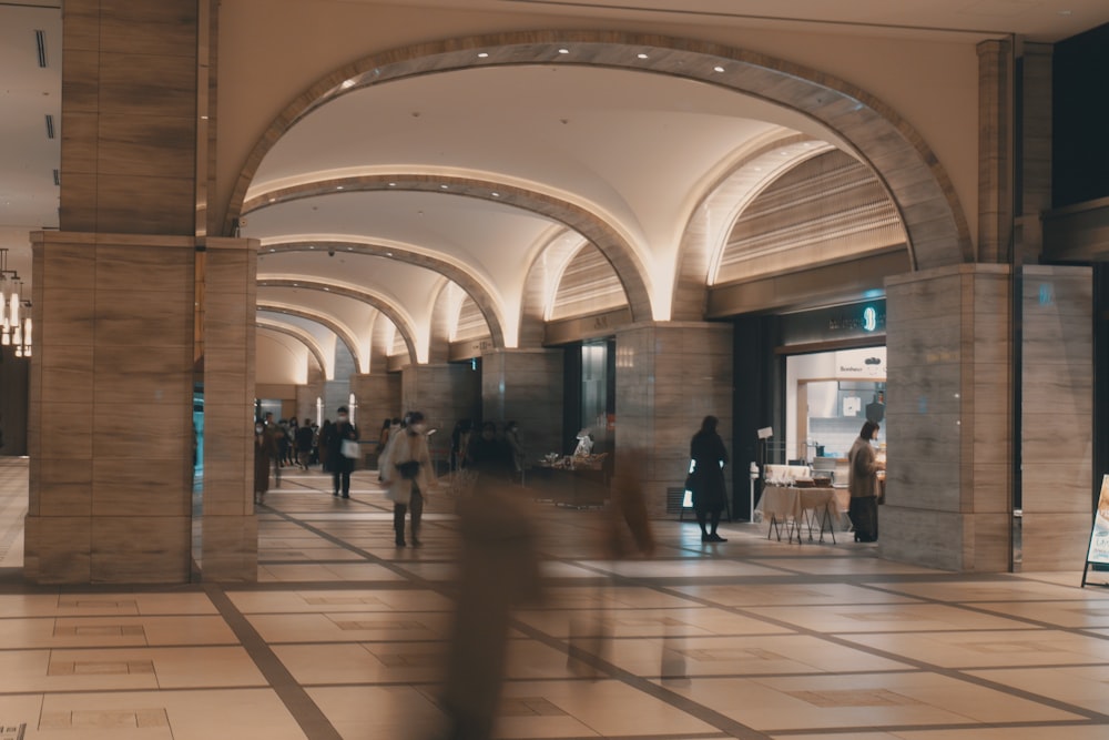 a group of people walking through a lobby