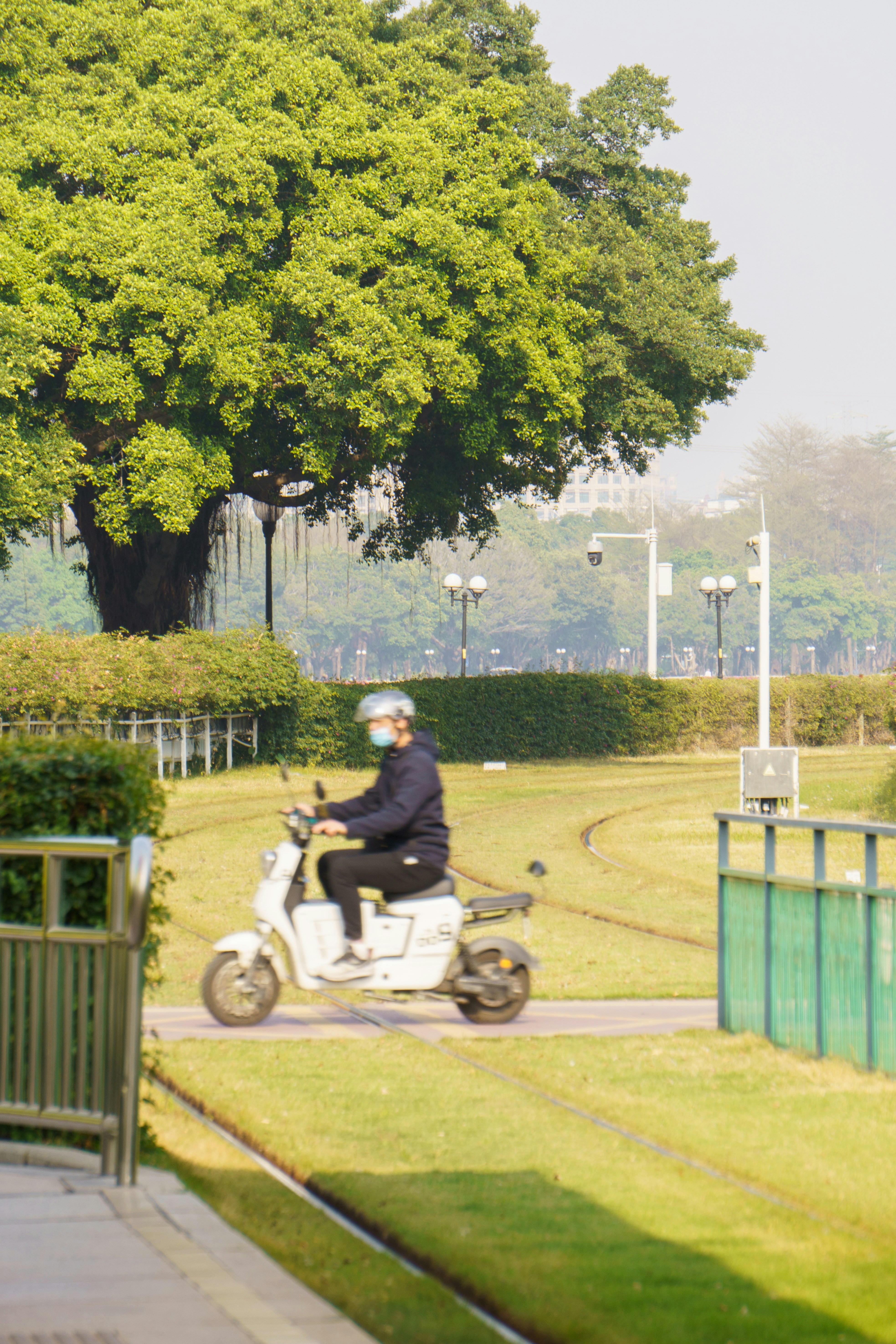 A man riding a scooter down a sidewalk photo Free Guangzhou Image on