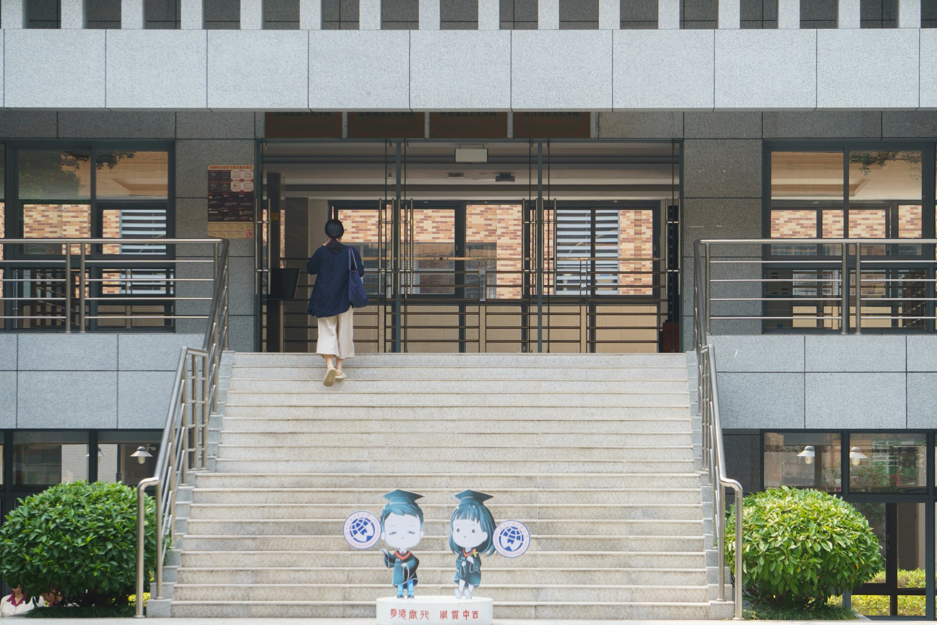 a man walking up a flight of stairs in front of a building