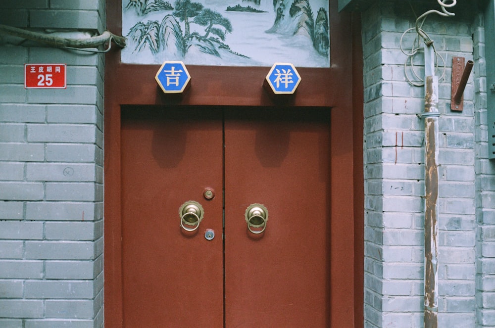 a red door with two blue and white signs on it
