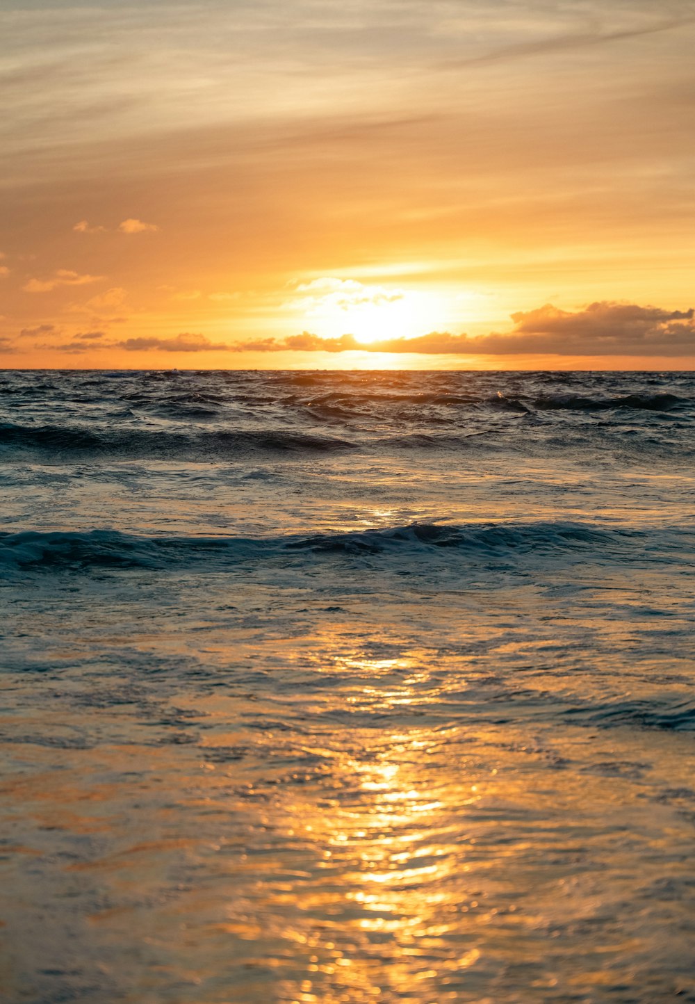 the sun is setting over the ocean with waves