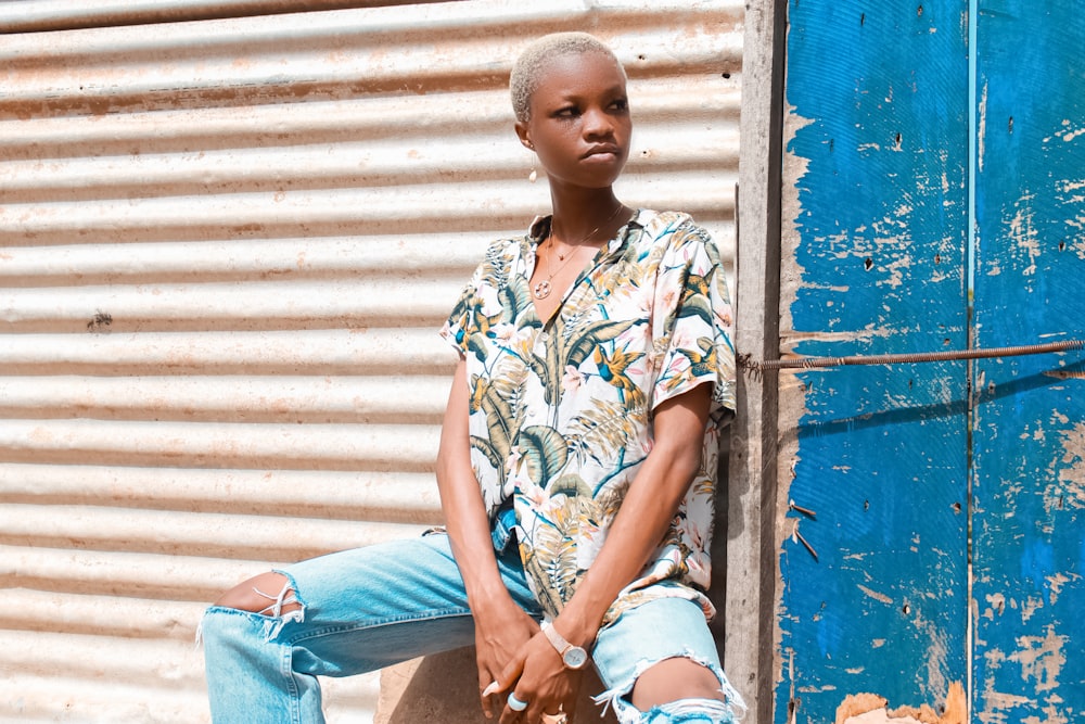 a woman sitting on a wall with her legs crossed