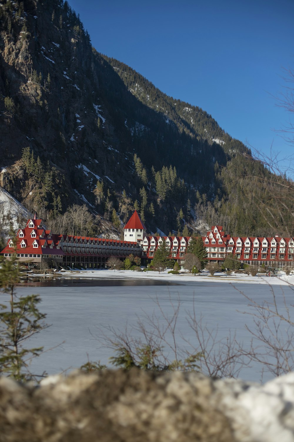 a red and white building sitting on top of a snow covered hillside