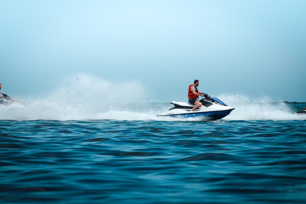 duas pessoas andando jet skis em um corpo de água