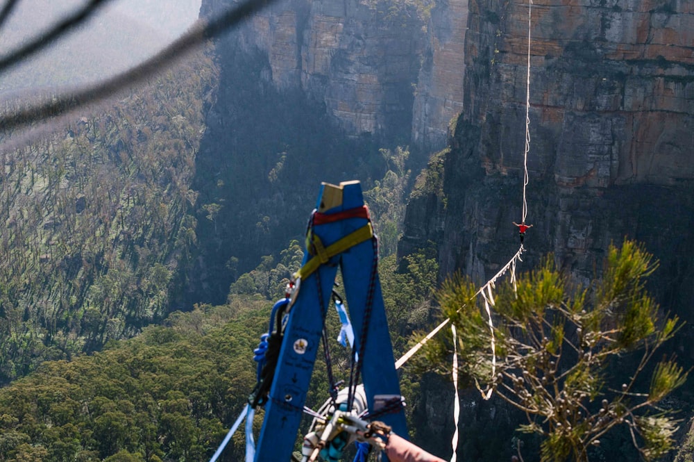 a person on a zip line high up in the mountains