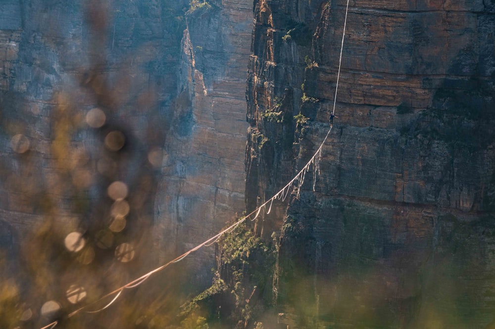 a man on a rope high up in the mountains