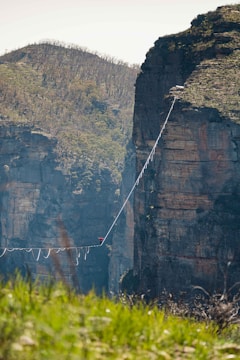 a man walking across a rope bridge over a river