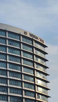 A sleek modern office building exterior at Menara 165, Jakarta Selatan, with clear signage of ears-m & rekan law firm.