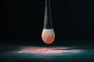 Brushes dipped in shimmering highlighter powder, ready for application.