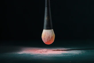 A sleek makeup brush painting a bold, colorful stroke on a modern canvas background